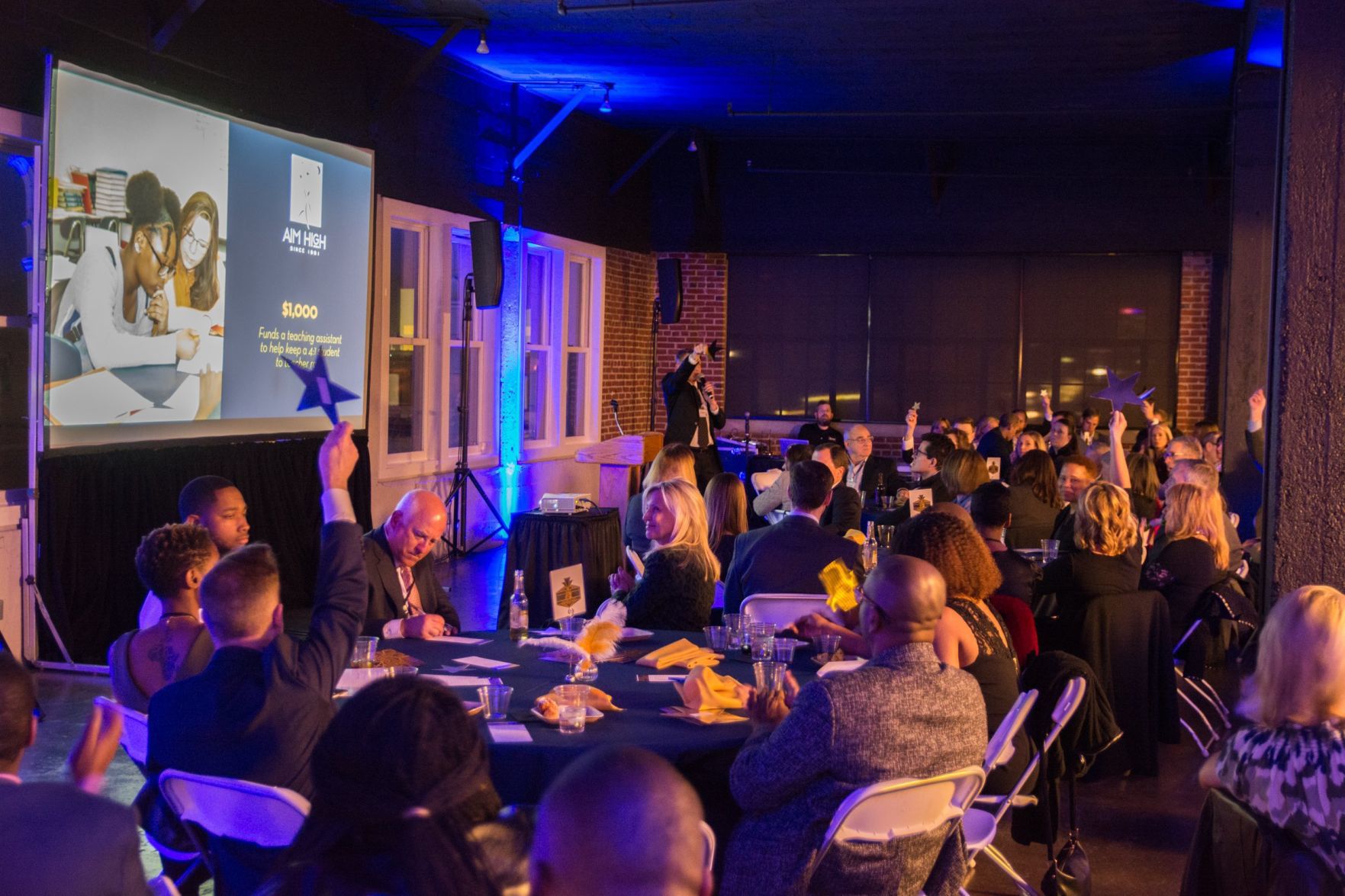 Attendees of the event raise stars for fundraising at the event